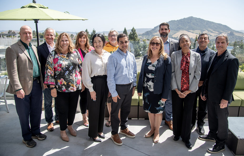 Cal Poly Partners board group photo on rooftop with San Luis Obispo hills in background