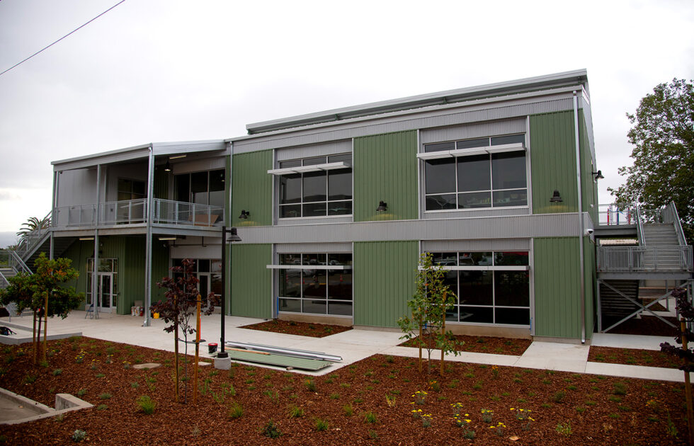 Modern green and gray two-story building at Cal Poly’s Technology Park with fresh landscaping