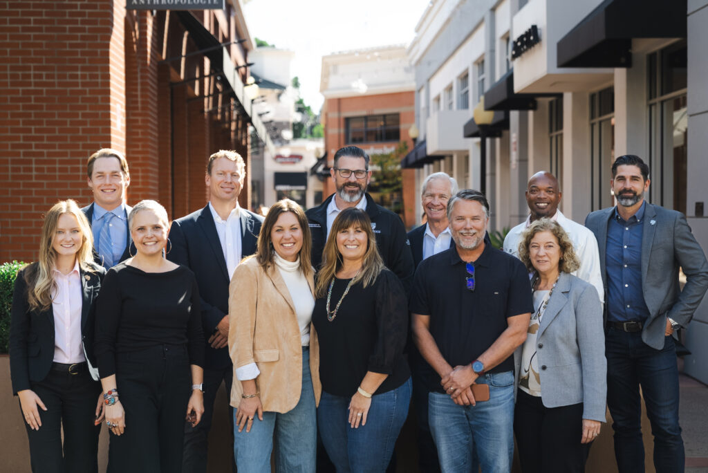 Group of Cal Poly Partners board members standing together outdoors in downtown San Luis Obispo, smiling for a professional group photo.